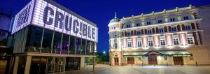 A photo of the Crucible and Lyceum theatres at night - all their lights are on