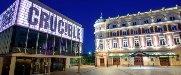 A photo of the Crucible and Lyceum theatres at night - all their lights are on