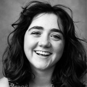 Head and shoulders photo of Shoshana Jones - she is looking into the camera with a big smile and a happy face. 