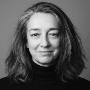 A balck and white headshot of zanna Hornby, she has a long brown bob, and is smiling into the lens.