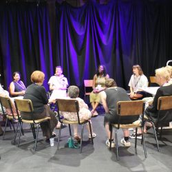 A group of people sitting in a circle in a workshop