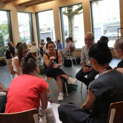 A group of people sitting in a circle in a workshop